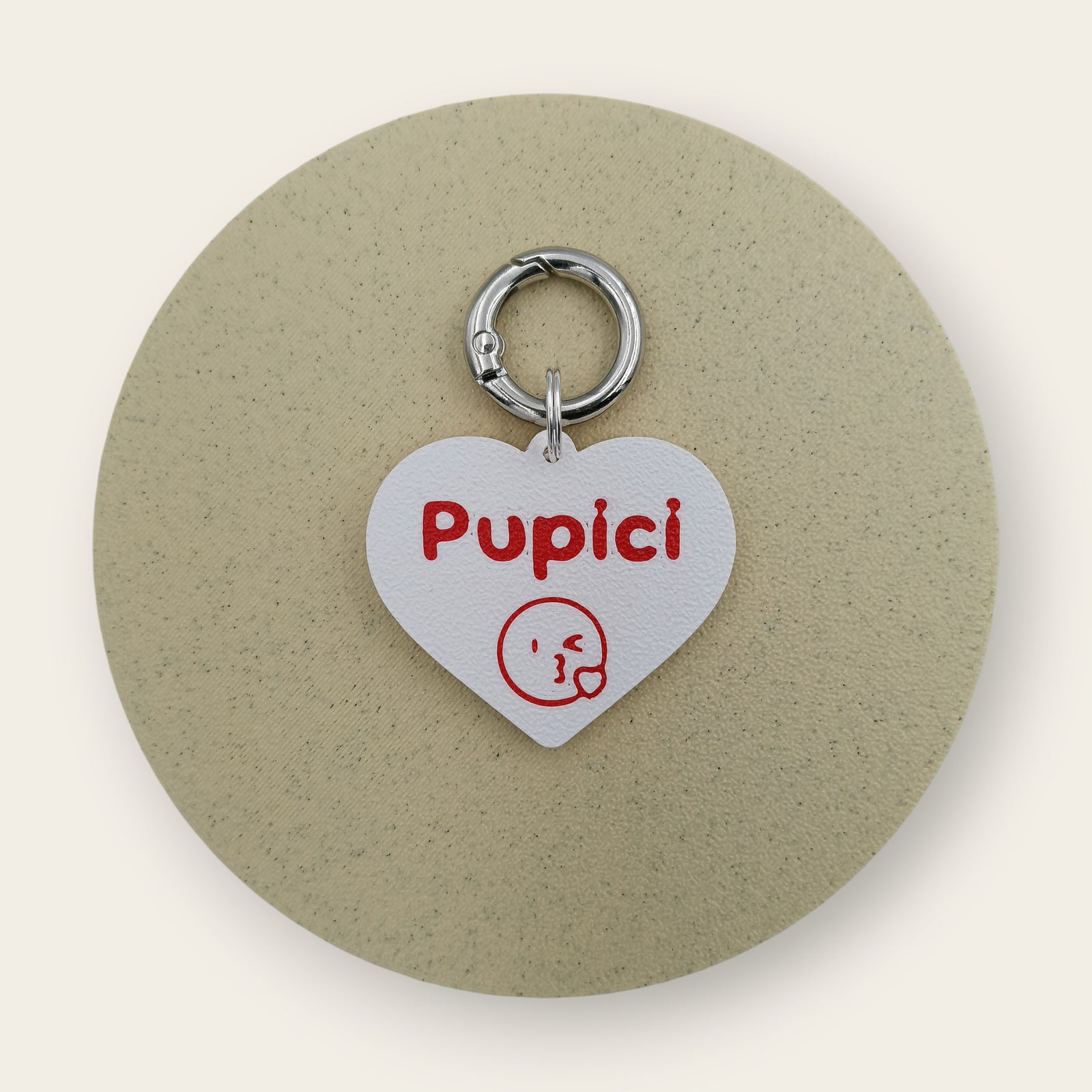 Medalion amuzant cu mesajul Pupici si simbol sub el, forma de inimioara alba cu text si emoticon rosu, printat 3D din PLA - Ubba.